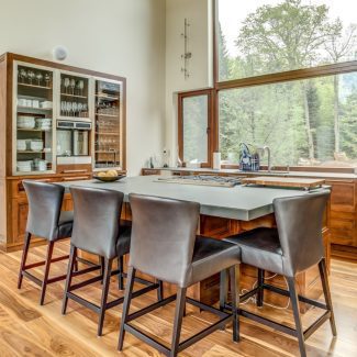 Kitchen with central island, wooden cabinets, and dark worktop.