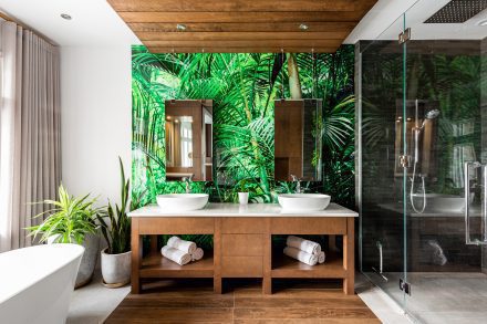 Green bathroom with dark cabinets and double sinks.