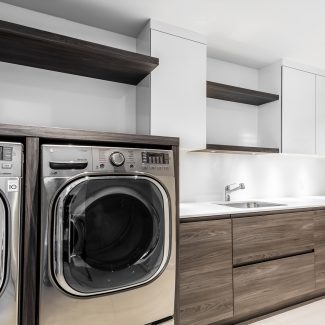 Modern laundry room layout with white quartz sink, cabinets, and countertops.