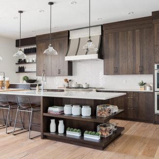 Cuisine moderne avec îlot central et armoires foncées.
