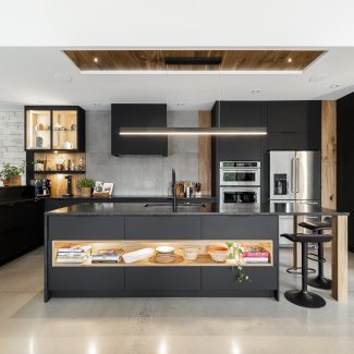 Intérieur d'une cuisine aménagée avec des comptoirs foncés et des luminaires élégants.