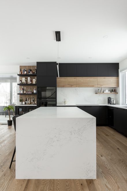 Modern dark kitchen furniture with central island and built-in lighting.