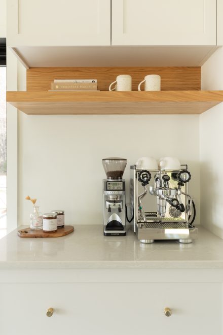 Cuisine contemporaine avec un coin barista avec des armoires blanche, poitngées en laiton conçue par Ateliers Jacob.