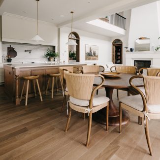 Cuisine lumineuse avec îlot en bois, comptoir en pierre claire et salle à manger intégrée, réalisée par Ateliers Jacob.