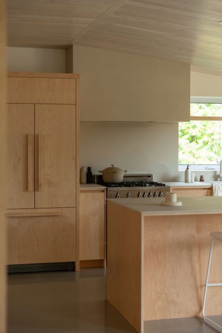 Cuisine inspirée du style scandinave par Ateliers Jacob, avec armoires et îlot en bois clair, hotte minimaliste et comptoirs sobres baignés de lumière naturelle.