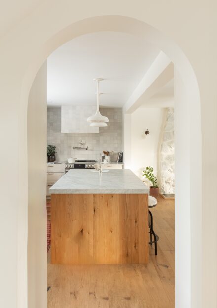 California inspired kitchen design made by Ateliers Jacob with a kitchen island, floating shelves in oak.