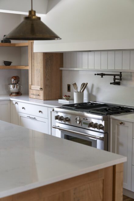 Cuisine Ateliers Jacob en laque et chêne, rehaussée de comptoirs et d’un dosseret en quartz. Une composition équilibrée où la chaleur du bois dialogue avec la pureté des surfaces minérales.