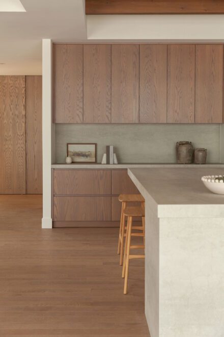 Cuisine Ateliers Jacob en chêne et laque, avec comptoirs et dosseret en porcelaine Laminam Pietra Di Savoia Perla. Une palette de matériaux où les textures naturelles et les surfaces minérales se complètent.