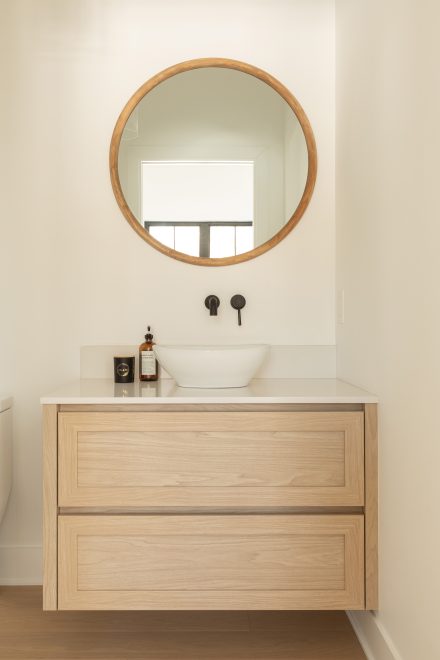 Custom made vanity from Atleliers Jacob with oak wood, and round mirror