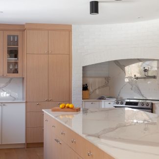 Cuisine contemporaine conçue par Ateliers Jacob avec des armoires en chênes et blanches ainsi qu'un grand îlot central