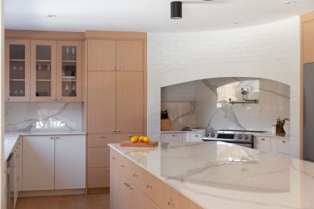 Cuisine contemporaine conçue par Ateliers Jacob avec des armoires en chênes et blanches ainsi qu'un grand îlot central