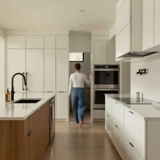 Une cuisine contemporaine conçu par Ateliers Jacob avec des armoires blanches et un ilot en bois clair