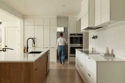 Une cuisine contemporaine conçu par Ateliers Jacob avec des armoires blanches et un ilot en bois clair