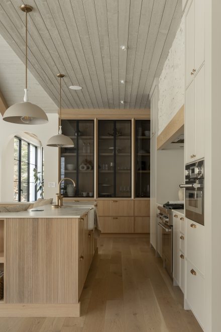 cuisine farmhouse avec un ilot central en chêne et des armoires murales beige Ateliers Jacob