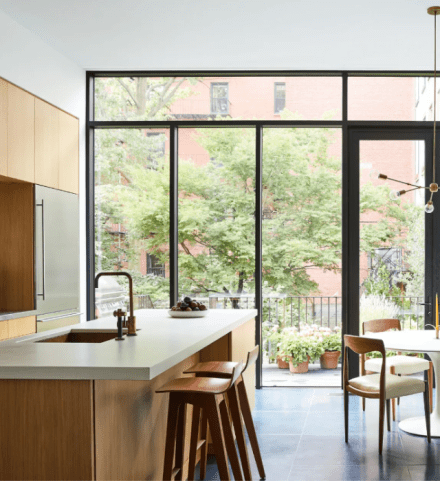 Cuisine lumineuse avec îlot en béton teinté poli sur mesure, combiné à des armoires texturées en bois pâle.