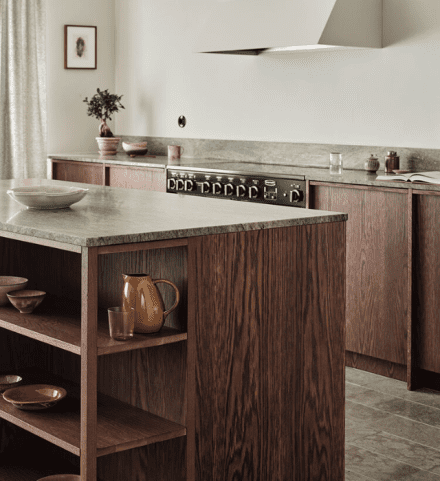 uisine chaleureuse avec comptoir et dosseret en granite naturel, combiné à des armoires en bois foncé.