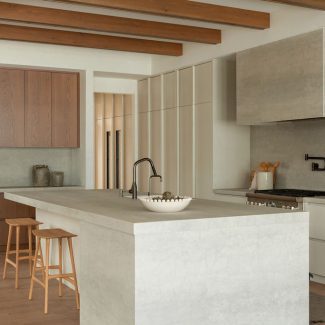 Alliant porcelaine aux textures minérales, hotte encastrée et armoires sans poignées, cette cuisine minimaliste révèle toute la sensibilité du style Japandi. Une réalisation signée Ateliers Jacob.