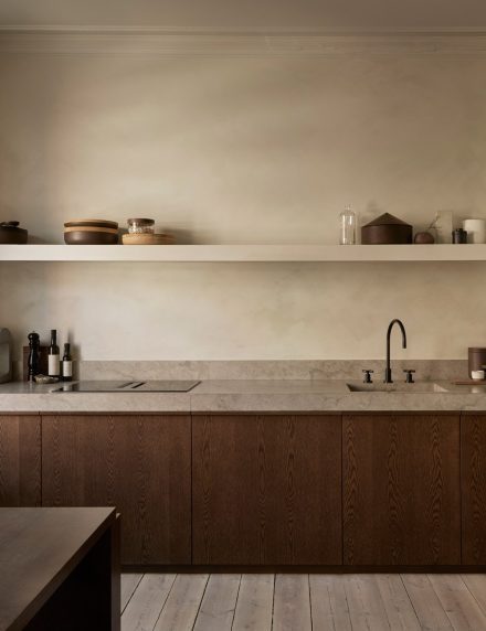 A Japandi-style kitchen from Nordiska Kok with organic modern design, earthy colors, lime plaster walls, oak, limestone countertops, and a harmonious interior.