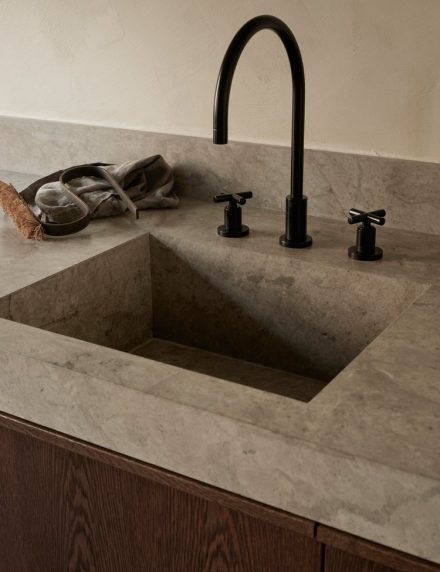 A Japandi-style kitchen from Nordiska Kok with organic modern design, earthy colors, lime plaster walls, oak, limestone countertops, and a harmonious interior.