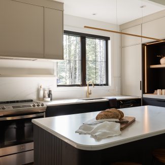 Cuisine sur mesure signée Ateliers Jacob avec comptoir en surface claire effet marbre, îlot central arrondi et dosseret assorti, idéale pour explorer les options de matériaux de comptoir.

