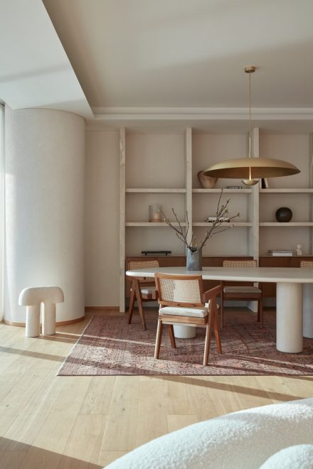 Salle de réunion minimaliste baignée de lumière, avec bibliothèque encastrée, mobilier aux lignes courbes et palette naturelle inspirant le design des bureaux de La Pièce.