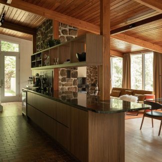 Cuisine Mid-Century moderne conçue par Ateliers Jacob pour Cœur de Pirate, avec armoires en laminé européen effet bois et plancher en brique.