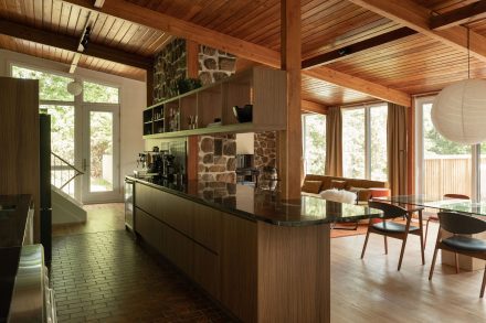 Cuisine Mid-Century moderne conçue par Ateliers Jacob pour Cœur de Pirate, avec armoires en laminé européen effet bois et plancher en brique.