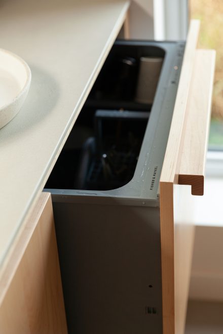 Lave-vaisselle tiroir Fisher & Paykel intégré derrière une façade sur mesure en érable, dans une cuisine haut de gamme signée Ateliers Jacob.
