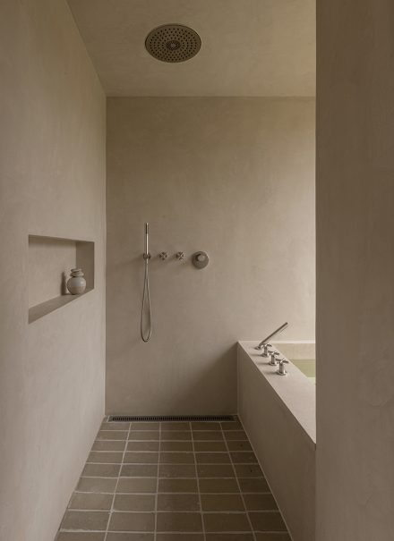Salle de bain Heatherhill Beach House par Norm Architects avec douche à l’italienne et bain, où l’aménagement ingénieux et le positionnement du robinet du bain optimisent l’espace avec sobriété.