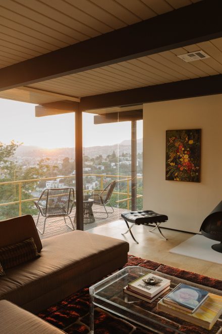 Salon de la Garduno-Heiser Home conçu par Raul Garduno, avec large fenestration donnant sur la ville au coucher du soleil et mobilier Mid-Century moderne.