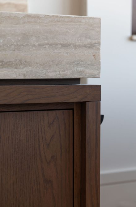 Détail d’un comptoir en pierre naturelle qui allie élégance et durabilité dans une salle de bain signée Ateliers Jacob