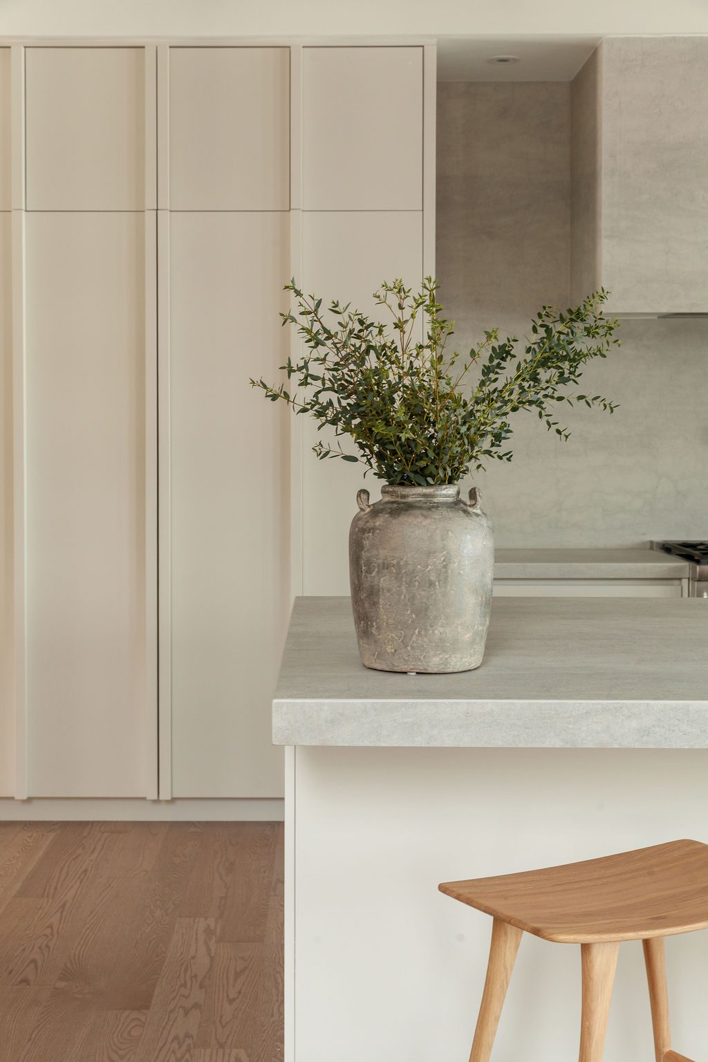 Vase en terre cuite sur le comptoir en surface minérale de la cuisine Farand, soulignant l’équilibre des matières naturelles.