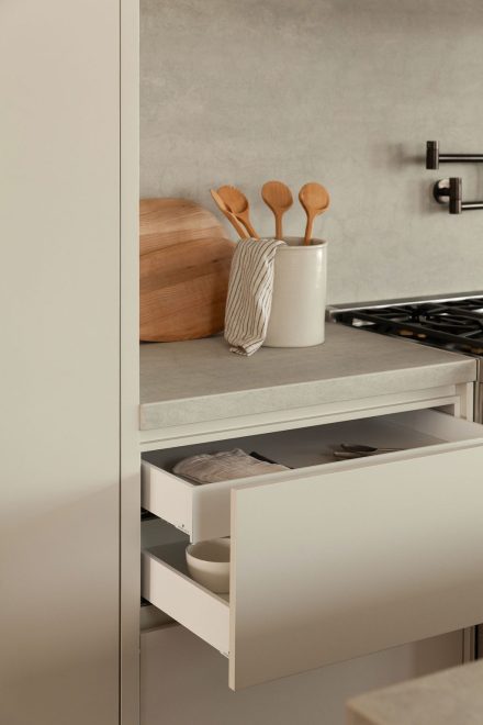 Détail des tiroirs intégrés dans la cuisine Farand, montrant une organisation discrète et une continuité harmonieuse avec les surfaces en Laminam.