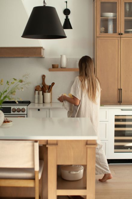 Préparation tranquille d’un repas en fin de journée, lumière douce et gestes simples autour de l’îlot.