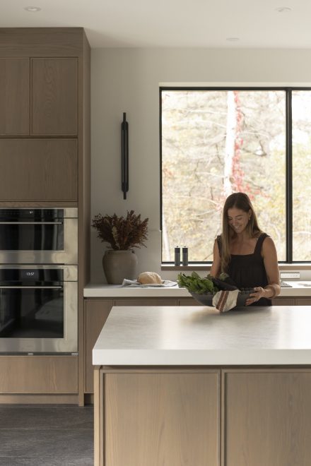 Préparation des aliments sur un îlot de cuisine, lumière naturelle, gestes lents et concentrés autour du moment de cuisiner.