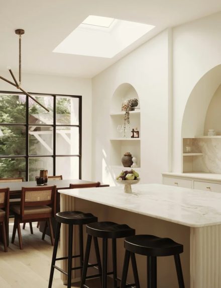 Cuisine Nordiska Kök près de Paris avec îlot aux angles arrondis et arches murales, mettant en valeur des formes organiques et une lumière naturelle douce.