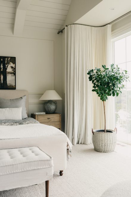 Dans la chambre, une plante prend place près de la fenêtre, la lumière naturelle traverse les rideaux et le feuillage accompagne le repos, dans ce projet signé Ateliers Jacob en collaboration avec Symbiose Design.