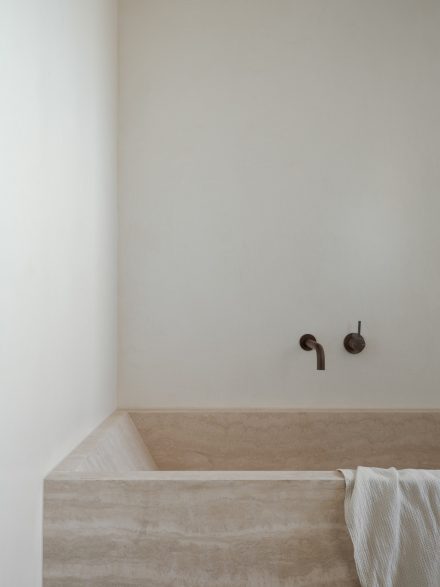 Un bain en travertin aux teintes sable, associé à des murs enduits à la chaux, crée un espace calme où la matière et la lumière invitent au repos. Projet: Madeleine Blanchfield Architects | Photo: Tom Ferguson