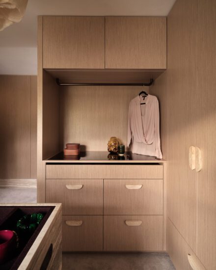 Détail d’un walk-in sur mesure avec garde-robe intégré, penderie ouverte et tiroirs en bois pour un rangement élégant et fonctionnel