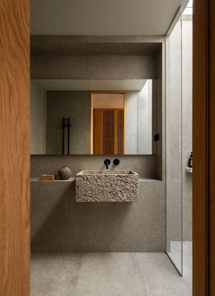 Les murs recouverts de chaux et la pierre aux teintes naturelles enveloppent la salle de bain d’une douceur minérale, où la lumière révèle lentement les textures et installe une ambiance propice au rituel et au calme. Projet: Sjöparken de Norm Architects | Photo: Jonas Bjerre-Poulsen