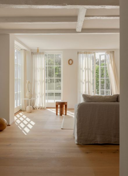 La lumière du jour glisse sur le plancher en chêne et révèle une palette douce, inspirée des beiges sablonneux et des gris feutrés du paysage environnant. Projet: Strandgården de Norm Architects | Photo: Jonas Bjerre-Poulsen, Karl Tranberg Knudsen, Sandie Lykke Nolsøe