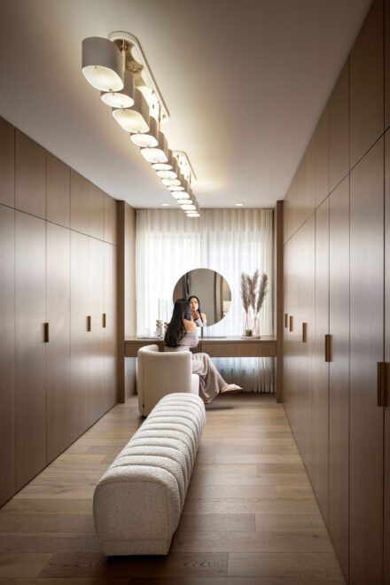 Dans ce projet d’Ateliers Jacob, le walk-in double parallèle structuré combine des rangements en chêne blanc et un banc central qui délimite l’espace, pour une lecture claire et harmonieuse de la pièce