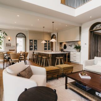 cuisine Ateliers Jacob avec perspective sur arche en bois, mobilier intégré sur mesure et circulation fluide entre les espaces