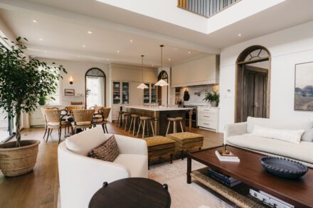 cuisine Ateliers Jacob avec perspective sur arche en bois, mobilier intégré sur mesure et circulation fluide entre les espaces