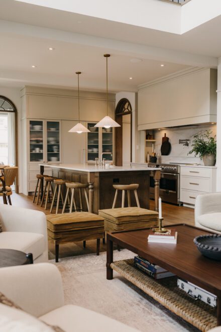 cuisine Ateliers Jacob en aire ouverte avec îlot central, tabourets en bois, salle à manger lumineuse et matériaux naturels
