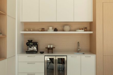 Coin barista intégré avec évier secondaire, tablette flottante et armoires crème dans une cuisine sur mesure Ateliers Jacob