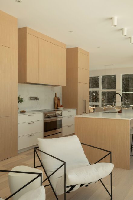 Cuisine haut de gamme Ateliers Jacob avec rangement pleine hauteur et matériaux naturels dans une maison contemporaine des Laurentides