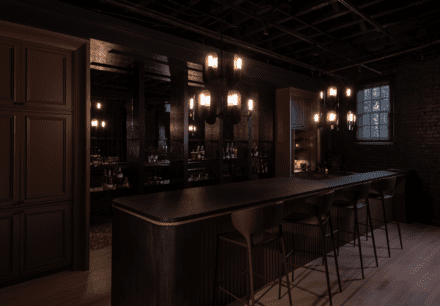 Speakeasy bar by Ateliers Jacob: fluted counter, antique mirrored wall and brass fixtures under an industrial ceiling for a moody, intimate vibe.
